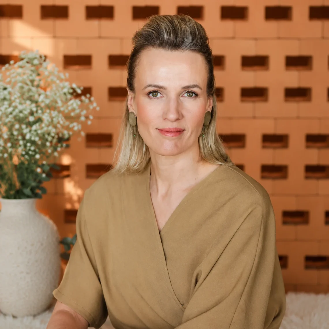Inga Mattiesen, terapeut – portreefoto beežis särgis teraapiakeskuse taustal