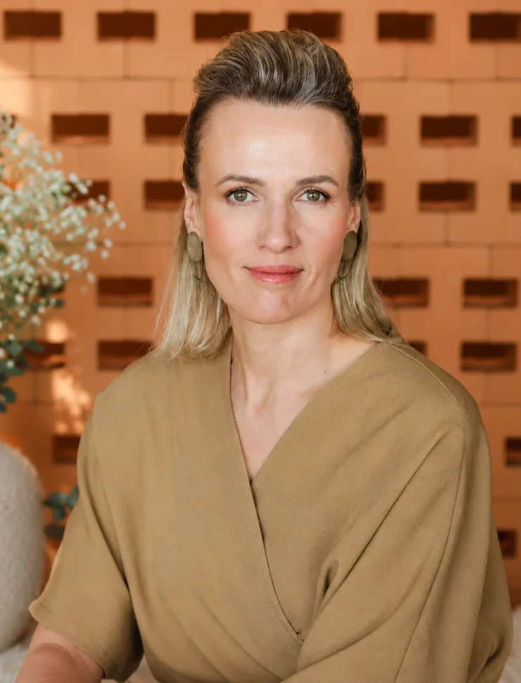 Inga Mattiesen, terapeut – portreefoto beežis särgis teraapiakeskuse taustal